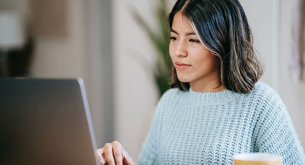 Eine junge Frau sitzt vor dem Laptop