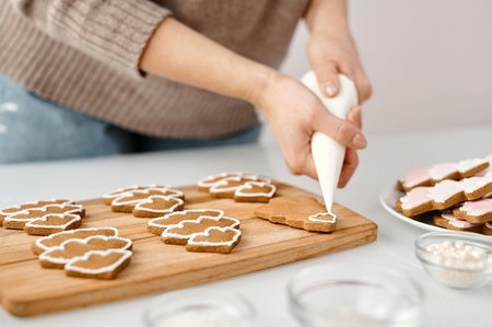 Eine Frau verziert Lebkuchen mit Zuckerguss