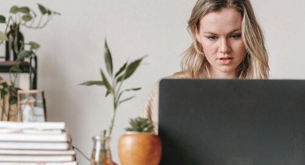Junge Frau sitzt am Laptop
