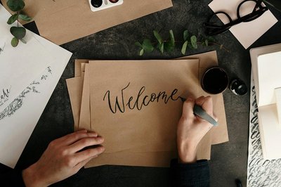 Eine Person schreibt in Kalligraphie auf ein Pergamentpapier