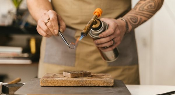 Ein Goldring wird geschmiedet, man sieht nur die arbeitenden Hände