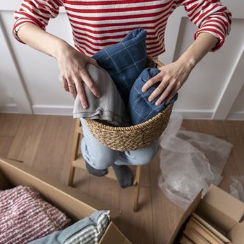 Eine Frau räumt den Kleiderschrank auf.