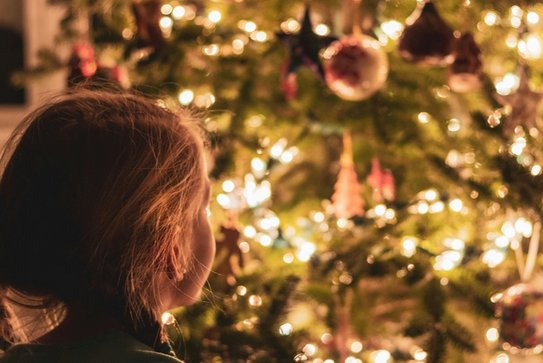 Ein staunendes Kind vor dem Weihnachtsbaum
