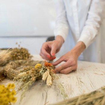 Ein Kranz aus Naturmaterialien wird gebunden
