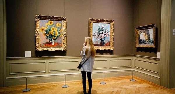 Junge Frau betrachtet ein Gemälde im Museum