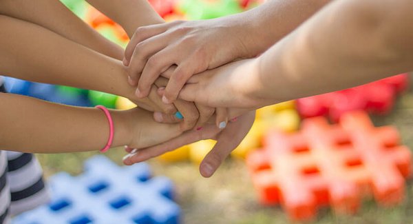 Mehrere Kinderhände liegen aufeinander