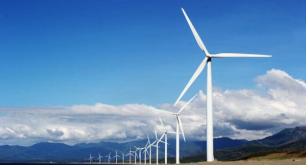 Eine Reihe von Windrädern vor einem blauen Himmel