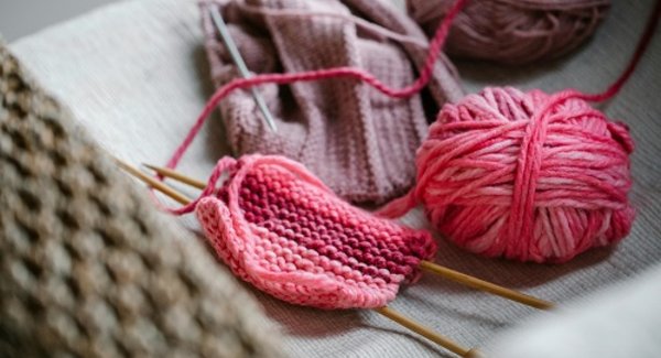 Bunte Wollknäule und Stricknadeln