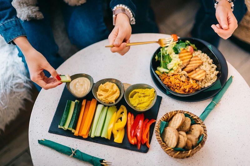 Salat und Rohkost mit verschiedenen Dips auf einem Tisch