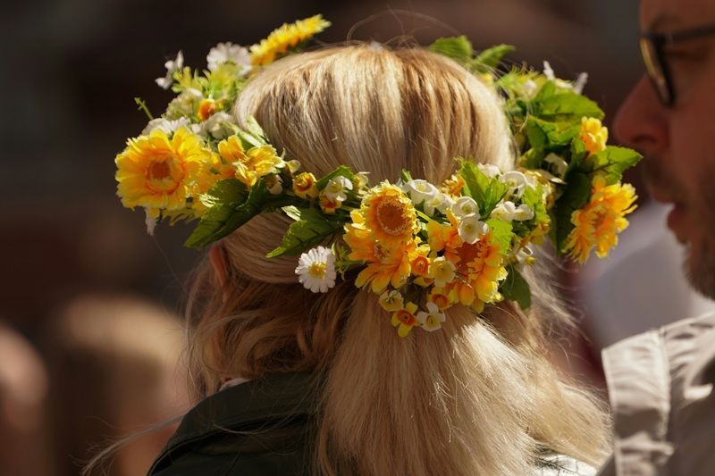 Eine Frau tr&auml;gt einen Blumenkranz auf dem Kopf.