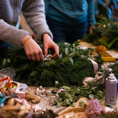 Eine Frau dekoriert einen Adventskranz.